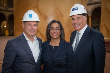 Men in hard hats with a woman in glasses