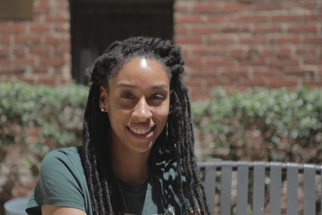 Black woman with braids smiles in the sunshine