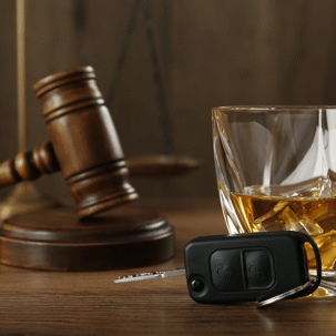 whiskey with car keys nearby and a legal gavel